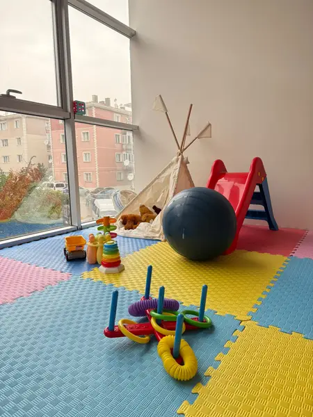 Oyun odasında kaydırak, top ve halka istifleme oyuncakları