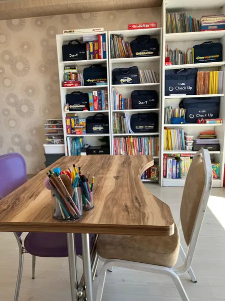 Bireysel eğitim masası ve program setlerinin durduğu kitaplık