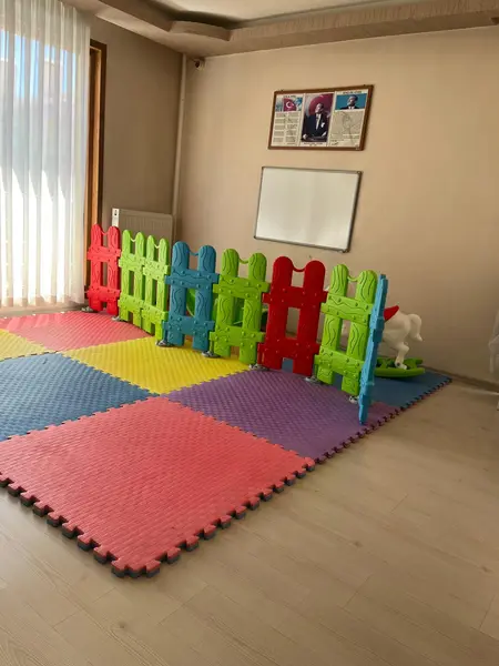 Renkli çitle ayrılmış yumuşak zeminli oyun alanı